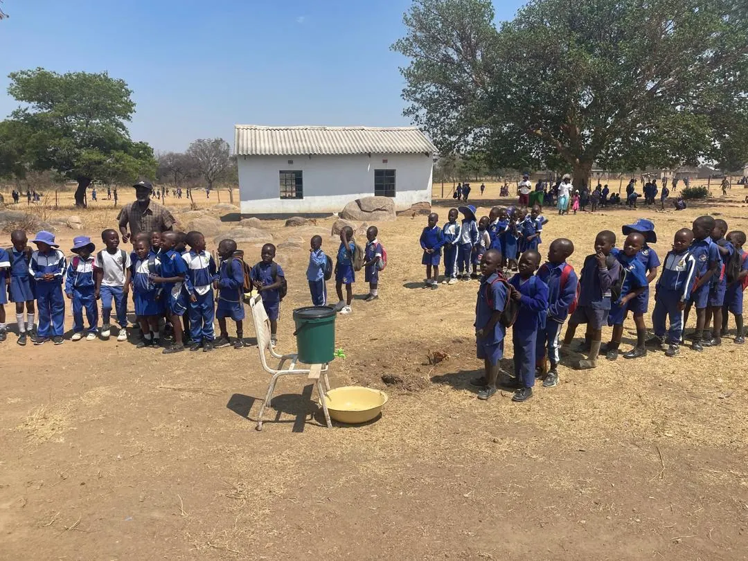 Children and teachers in a schoolyard in Zimbabwe.